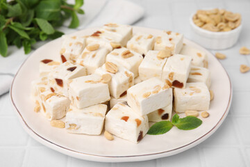 Pieces of delicious nutty nougat on plate, closeup