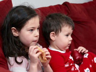 siblings having snacks on the couch