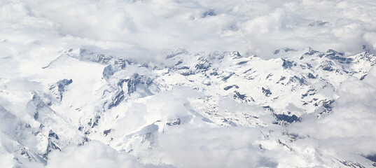Mountain high: Aerial view of snow-capped mountains in the clouds