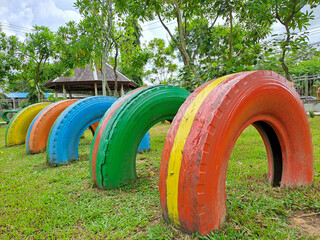 Painted tires are placed in lines which are used to create obstacles in the children's play area