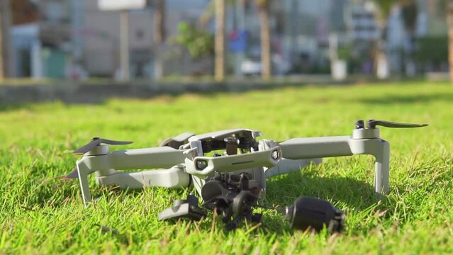Accident with a drone. Damaged quadcopter falls on green grass