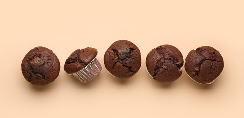 Tasty chocolate muffins on beige background