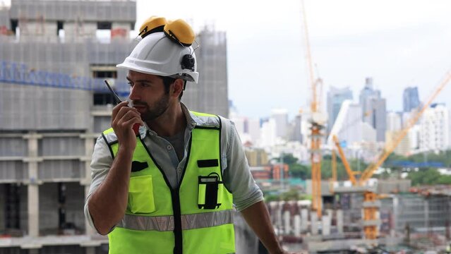 Slow-motion Construction engineer hard working on site of new building construction, architect with safety vest and hard hat working at construction site line