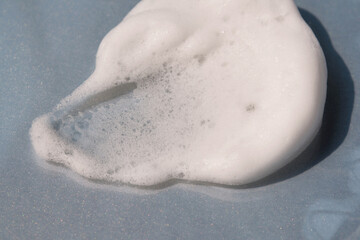 Soap foam on a light grey background.
