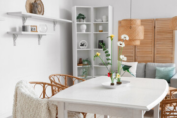 Beautiful ikebana on dining table in room