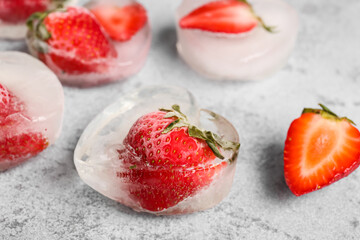 Fresh strawberry frozen in ice on grunge background