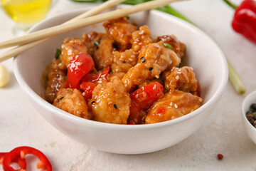 Bowl with tasty sweet and sour chicken on white background, closeup