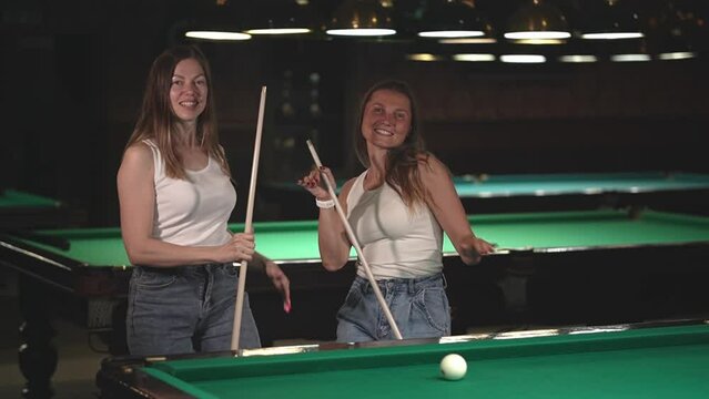 two women are dancing. two women are playing billiards. slow motion video. High quality Full HD video recording