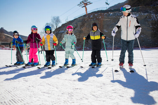 Children learning how to ski with their coach