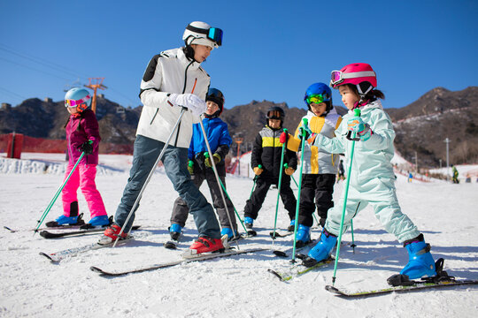 Children learning how to ski with their coach