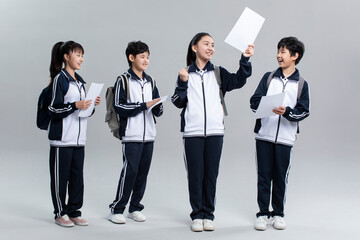 Cheerful students in uniform celebrating for their test results