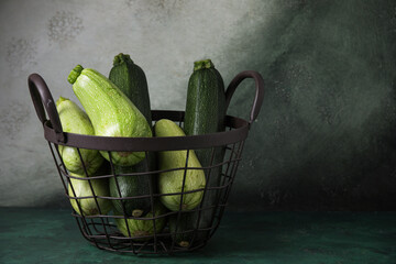 Basket with fresh zucchini on grunge background