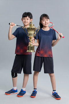 Cheerful girl and boy showing trophy