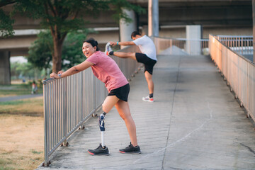 Woman wearing prosthetic equipment jogging in a park. Female walking and exercise works out outside.