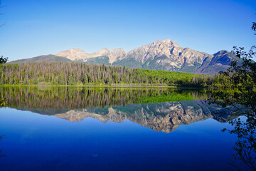 Fototapeta na wymiar Pyramid Mountain reflected in the early morning, still, glass like waters of the stunning Patricia Lake near Jasper in the Canada rockies
