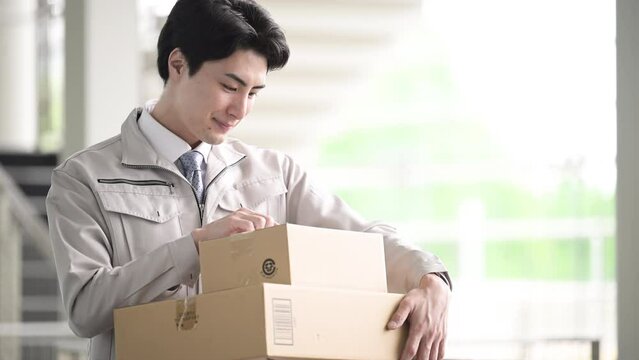 物流や運輸イメージ　工場、倉庫や配送センターで荷物を届ける作業員のアップの動画