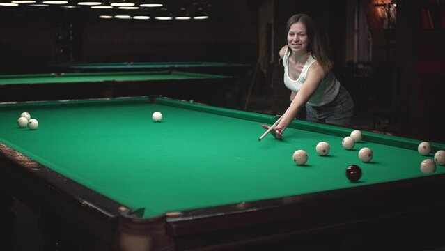 woman plays billiards. woman hammers a billiard ball into the hole. slow motion video. High quality Full HD video recording