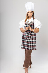 Indian female chef holding spoon in hand and giving happy expression on white background.