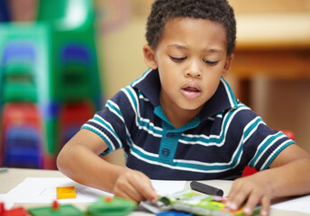 School, focus and a child drawing in a class for education, learning and creativity. Table, creative and a little male student doing art at kindergarten or creche to learn about color and playing