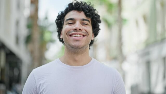 Young latin man smiling confident standing at street