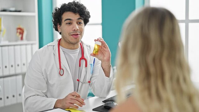 Young latin man doctor with patient prescribe pills treatment at clinic