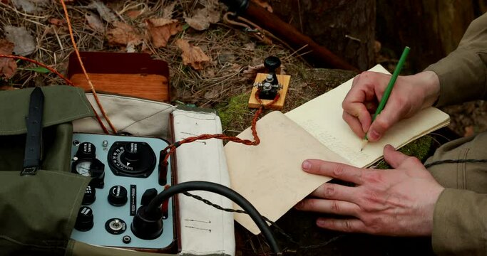 Russian Soviet Infantry Red Army Soldier In World War II using Russian Soviet Portable Radio Transceiver In Trench Entrenchment In Spring Autumn Forest. 4K. Headphones And Telegraph Key. Close Up