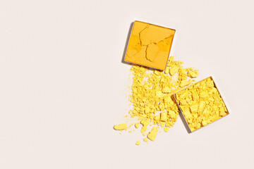 Yellow eye shadow texture, aesthetic minimal flat lay broken swatch of eye shadow powder on beige...