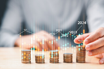 businessman analyzing stock trading graph financial data. Coins tower stacked on desk wooden,...