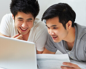 Smile, email and a gay couple with a laptop for bills, insurance or mortgage payment at home. Happy, bedroom and Asian men reading information to pay a loan with online banking on a computer