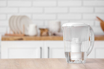 Water filter jug on table in modern kitchen