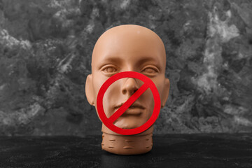 Human head with prohibition sign on dark table. Censorship concept