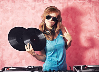DJ woman, mixer and portrait with vinyl records, sunglasses and horns sign at club, studio or...