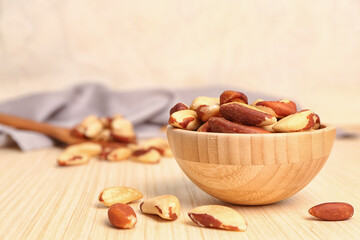 Bowl of delicious Brazil nuts on wooden table