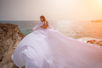 Fototapeta na wymiar Woman sea white dress. Happy freedom woman on the beach enjoying and posing in white dress. Rear view of a girl in a fluttering white dress in the wind. Holidays, holidays at sea.