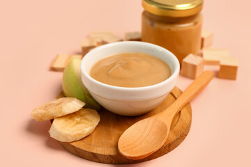 Bowl of healthy baby food on color background