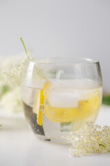 A cold summer drink made of elderflowers and lemon with ice
