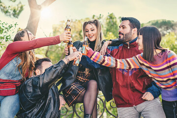 Friends Toasting and Celebrating Together - A group of caucasian friends, two men and three women, raising their bottles in a joyful toast, capturing the spirit of celebration and camaraderie.
