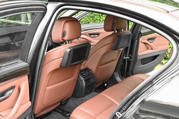 The rear passenger seat is wide and clean. Leather interior, side view, solar sunroof, buttons, Nappa leather, beige,black