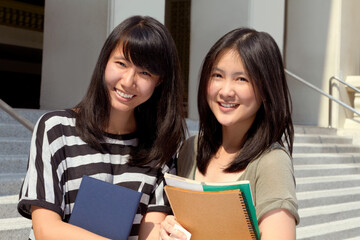 College, happy and portrait of girl friends with scholarship standing outdoor on campus for education. Knowledge, smile and Japanese female university students by a school building in the city.