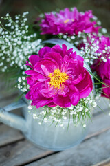 Blumenstrauß mit pinken Pfingstrosen und Schleierkraut, frische Blumen dekoriert in einer alten Vintage Gießkanne aus Metall, Landhaus Dekoration, Bauerngarten