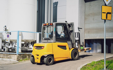Forklift loader near big industrial storage warehouse.