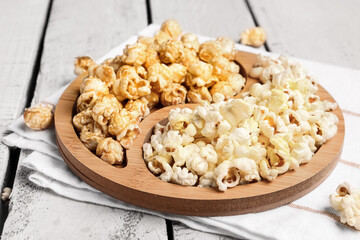 Plate with crispy popcorn on white wooden background