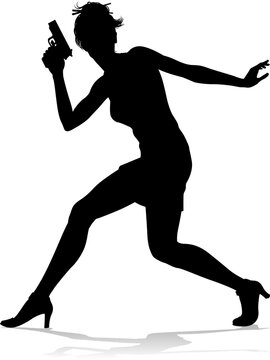 An action hero female movie star woman in silhouette. In a hitman, spy or secret agent detective type role halding a hand gun.