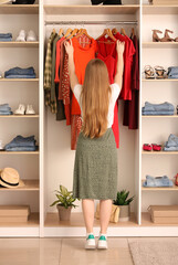 Young woman choosing clothes in boutique, back view