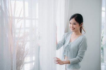 Portrait of young asian woman looking at camera. Beautiful girl with pleasant smile and happy. Cute woman standing and laughing.
