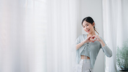 Portrait of young asian woman looking at camera. Beautiful girl with pleasant smile and happy. Cute woman standing and laughing.