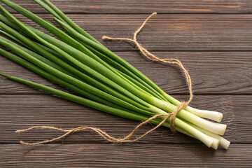 Bunch of fresh green onion on wooden background