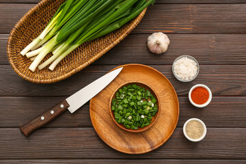 Fresh green onion with spices on wooden background