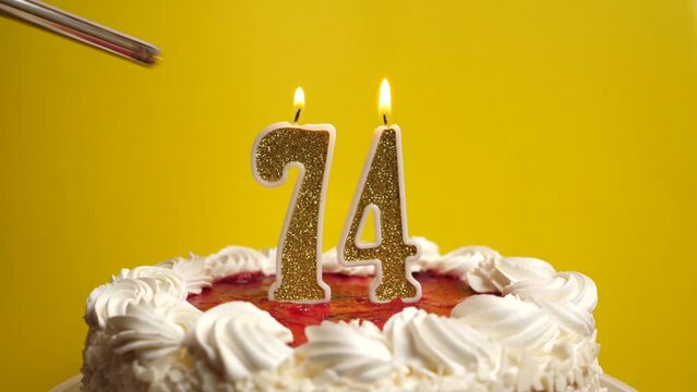 A candle in the form of the number 74, inserted into the holiday cake, is lit. Celebrating a birthday or a landmark event. The climax of the celebration.