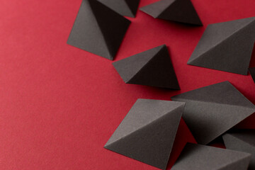 Fototapeta premium Black geometric shapes on red background, copy space